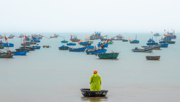 The coracle fisherman in the rain. Danang, Vietnam.