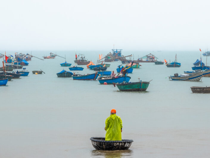 The coracle fisherman in the rain. Danang, Vietnam.