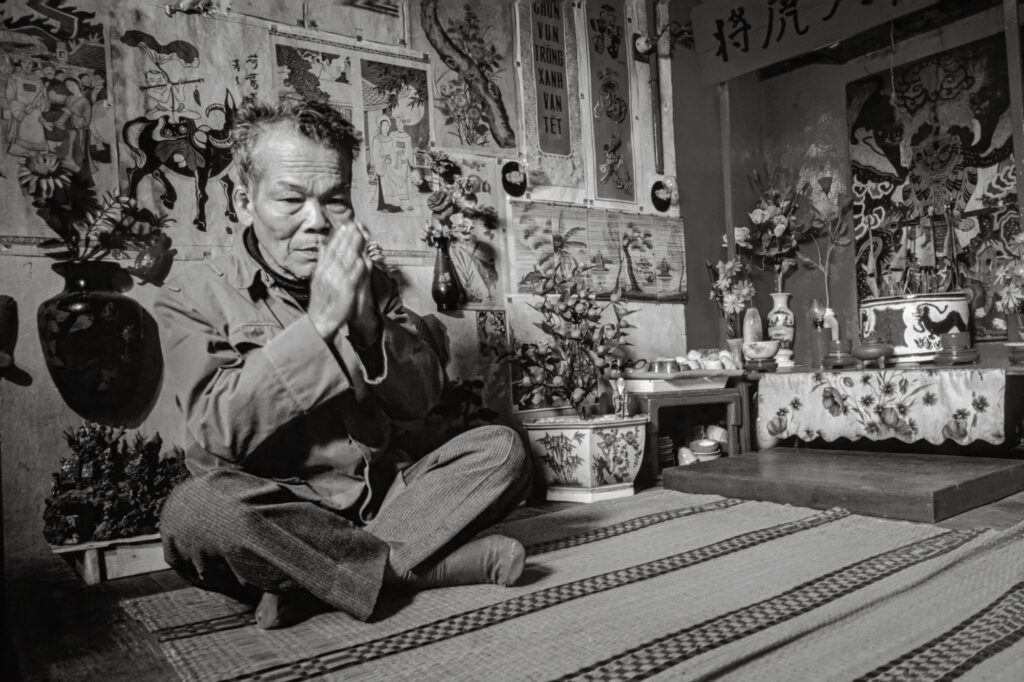 Mr Bui Huy Tuyen praying in his traditional house in Ngõ Phat Loc, 1993 / Ông Bùi Huy Tuyển cầu nguyện trong ngôi nhà truyền thống của ông ở ngõ Phát Lộc, 1993