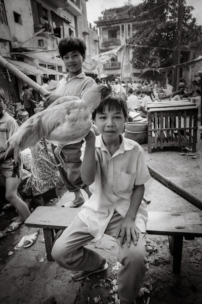 Boy with cockerill, Dong Xuan market, 1992 / Cậu bé với con gà trống, chợ Đồng Xuân, 1992