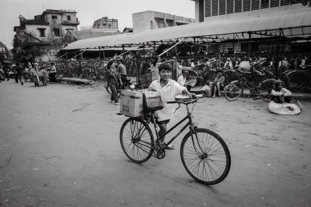 Boy with bicycle, Dong Xuan market, 1992 / Cậu bé với chiếc xe đạp, chợ Đồng Xuân, 1992