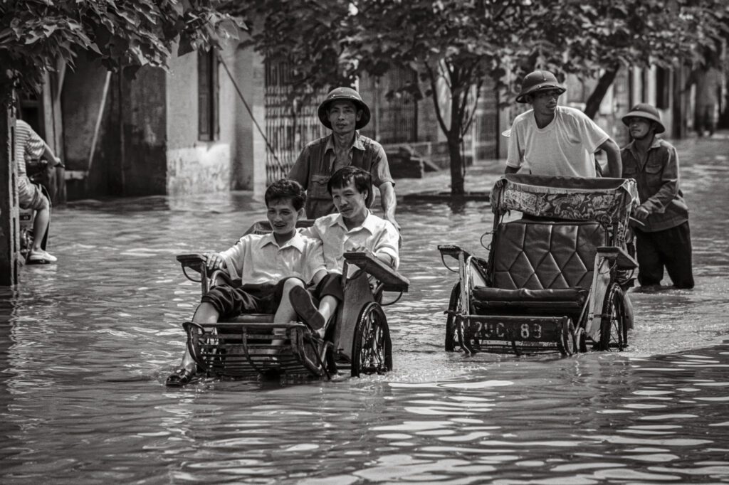 Cyclos in flooded Old Quarter, Hanoi, Vietnam, 1998. / Xe xích lô trong khu phố cổ Hà Nội ngập lụt, 1998.